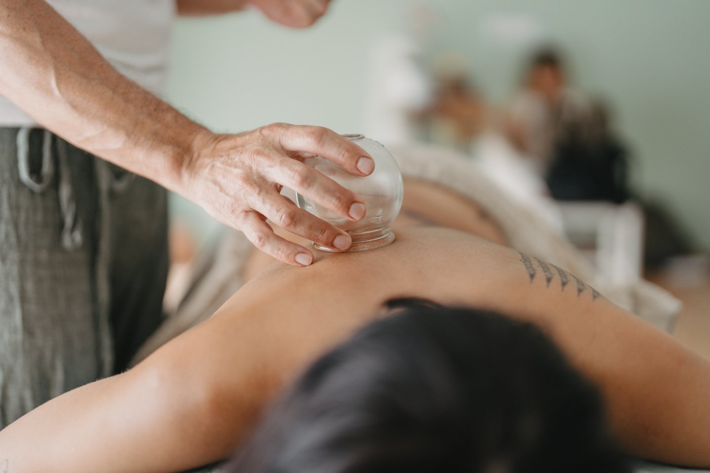 close-up of a masseur's hand moving a suction cup over a pat